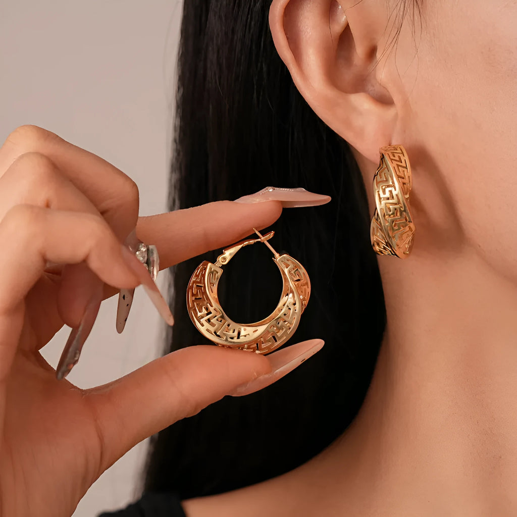 Women's twisted round geometric hollow stud earrings in silver or gold electroplated finish.