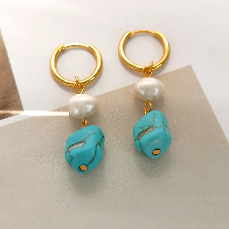 A pair of irregular shaped geometric copper ear clip earrings featuring turquoise stones and cultured pearls.