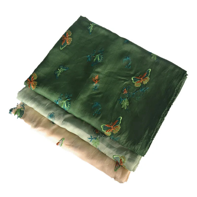 Roll of beige, grass green and dark green 100% ramie fabric for Hanfu sewing and embroidery, showing texture.