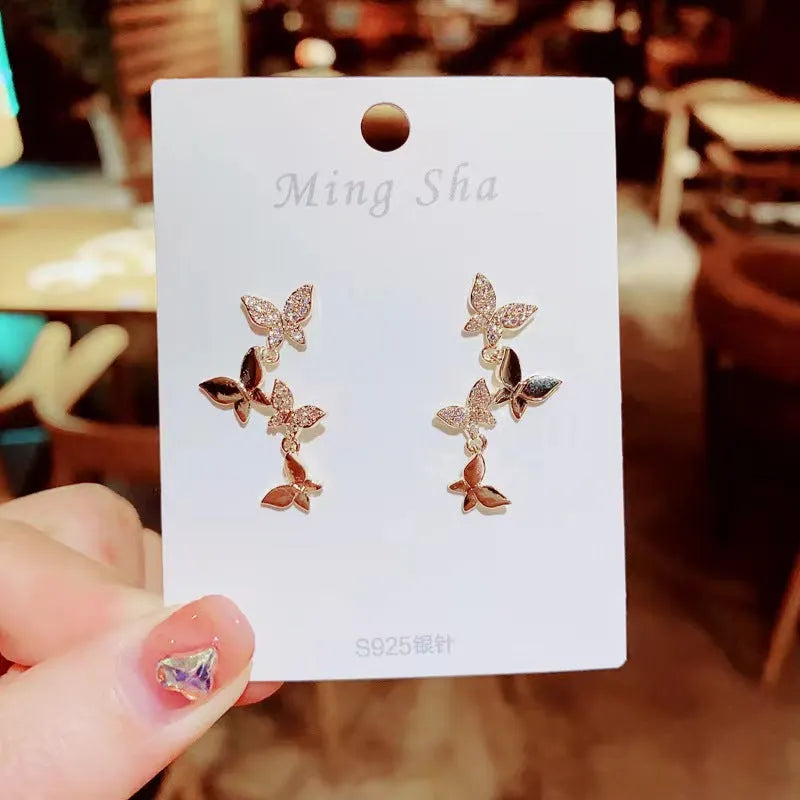 Women's copper butterfly earrings with four butterfly design in gold tone drop style
