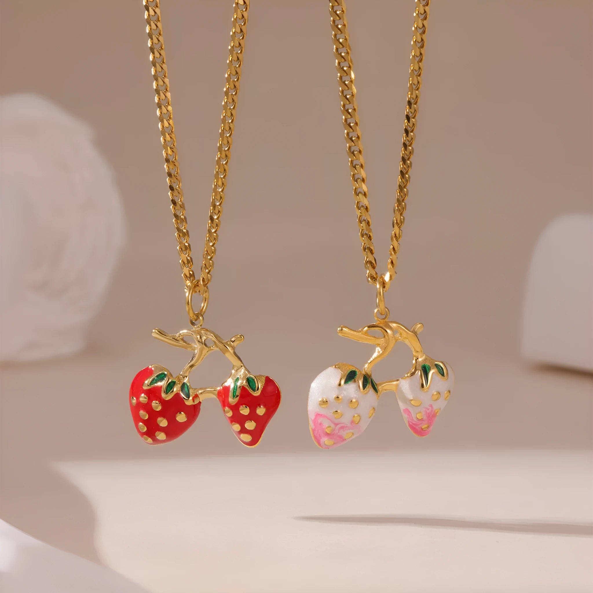 Close-up of a red stainless steel strawberry charm necklace on an alloy chain.