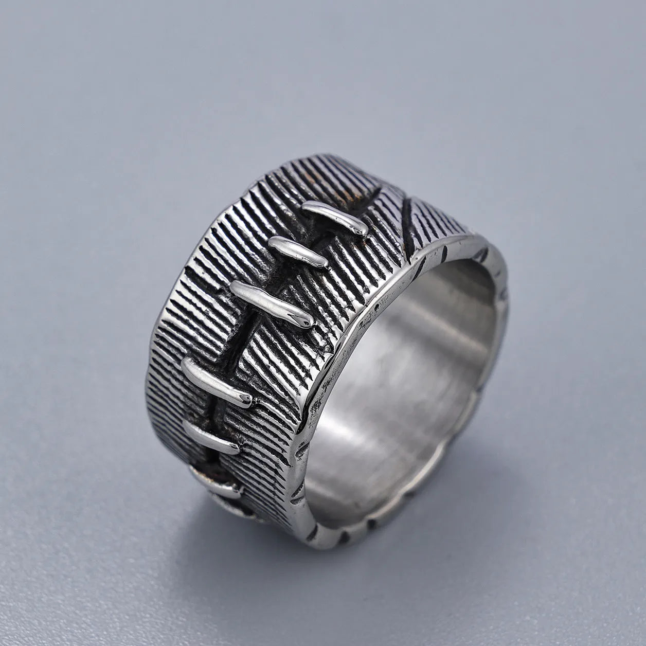 Geometric dark punk titanium steel double ring in retro colour on a black background.