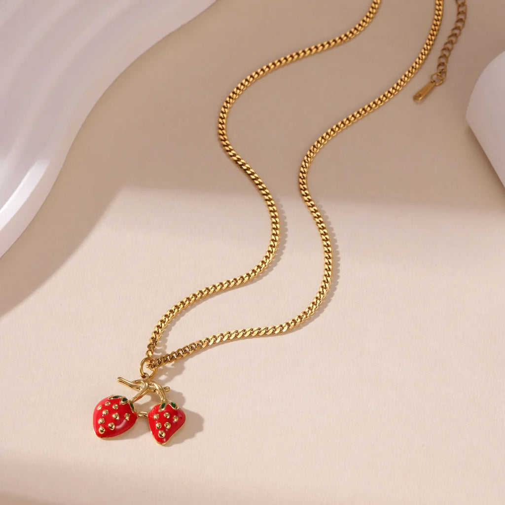 Close-up of a red stainless steel strawberry charm necklace on an alloy chain.