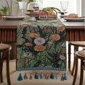 Beige jacquard table runner with floral pattern and long tassels laid flat on a table.