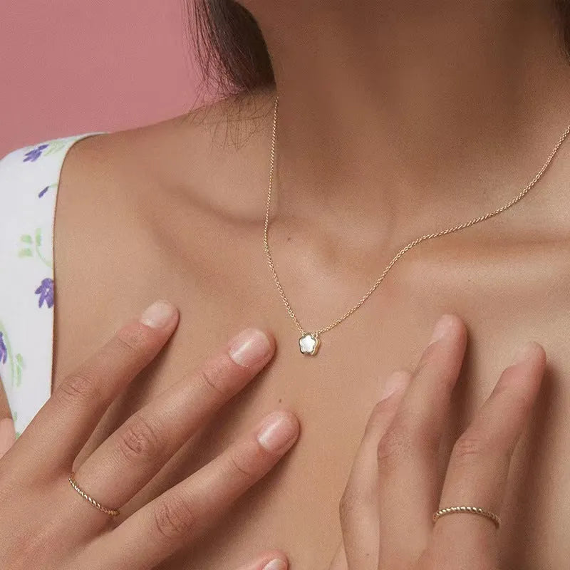 White mother of pearl shell flower necklace on a chain, shown in silver and gold tone finishes.