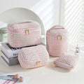 Four cube-shaped flannelette makeup bags in different colours for travel storage