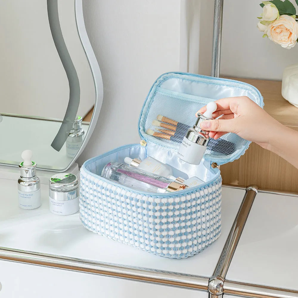Four cube-shaped flannelette makeup bags in different colours for travel storage