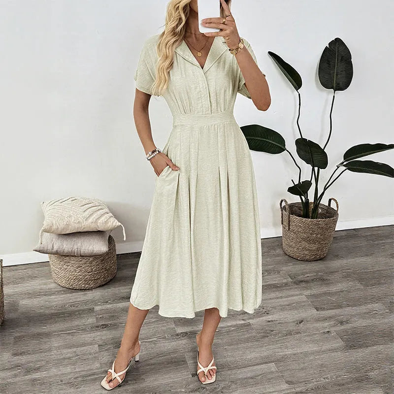 Light green knee-length shirt dress with lapel collar, waist tie, and side pockets on mannequin