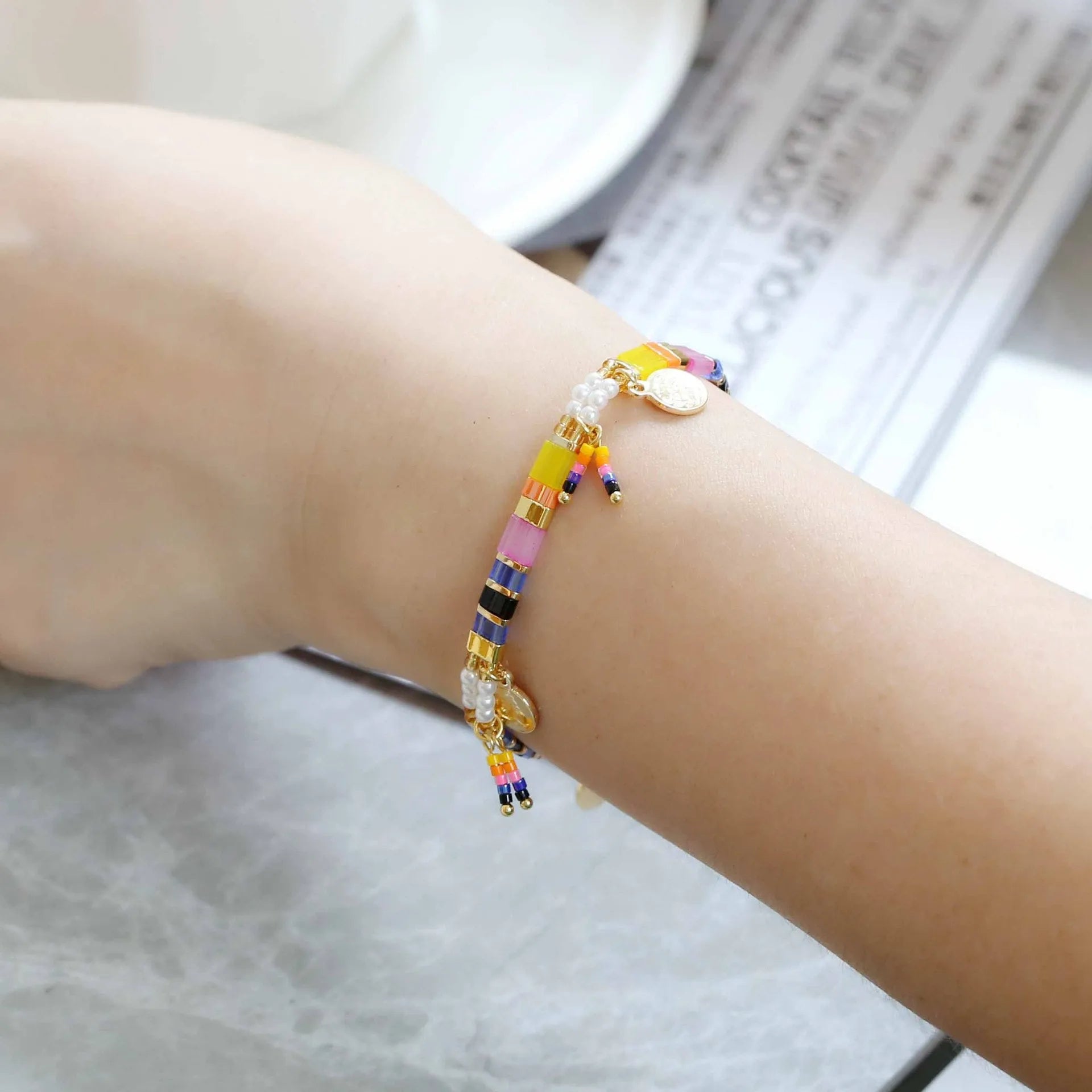 Women's imitation pearl and glass beaded bracelet showing six different colour variations with adjustable closure