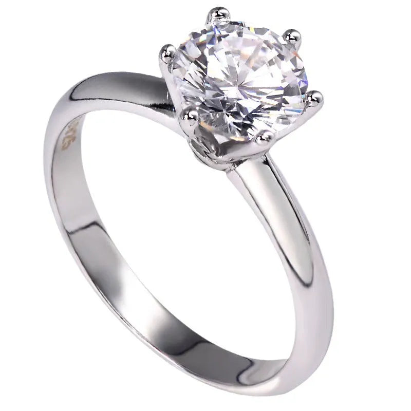 White gold plated geometric ring with a six-claw zircon setting on a hand.