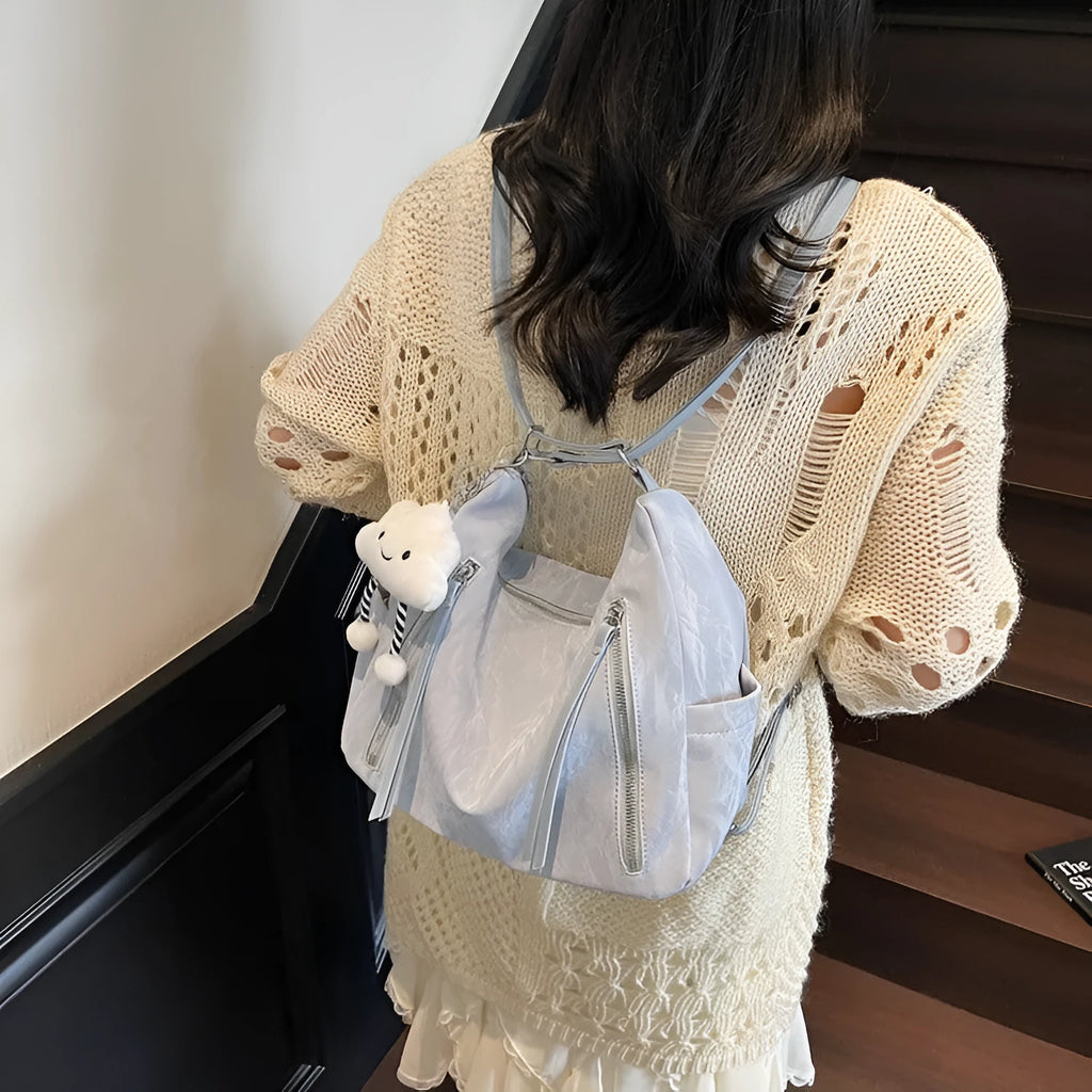Women's soft PU fashion backpack in black, shown as a multi-functional shoulder bag with a pendant accessory.