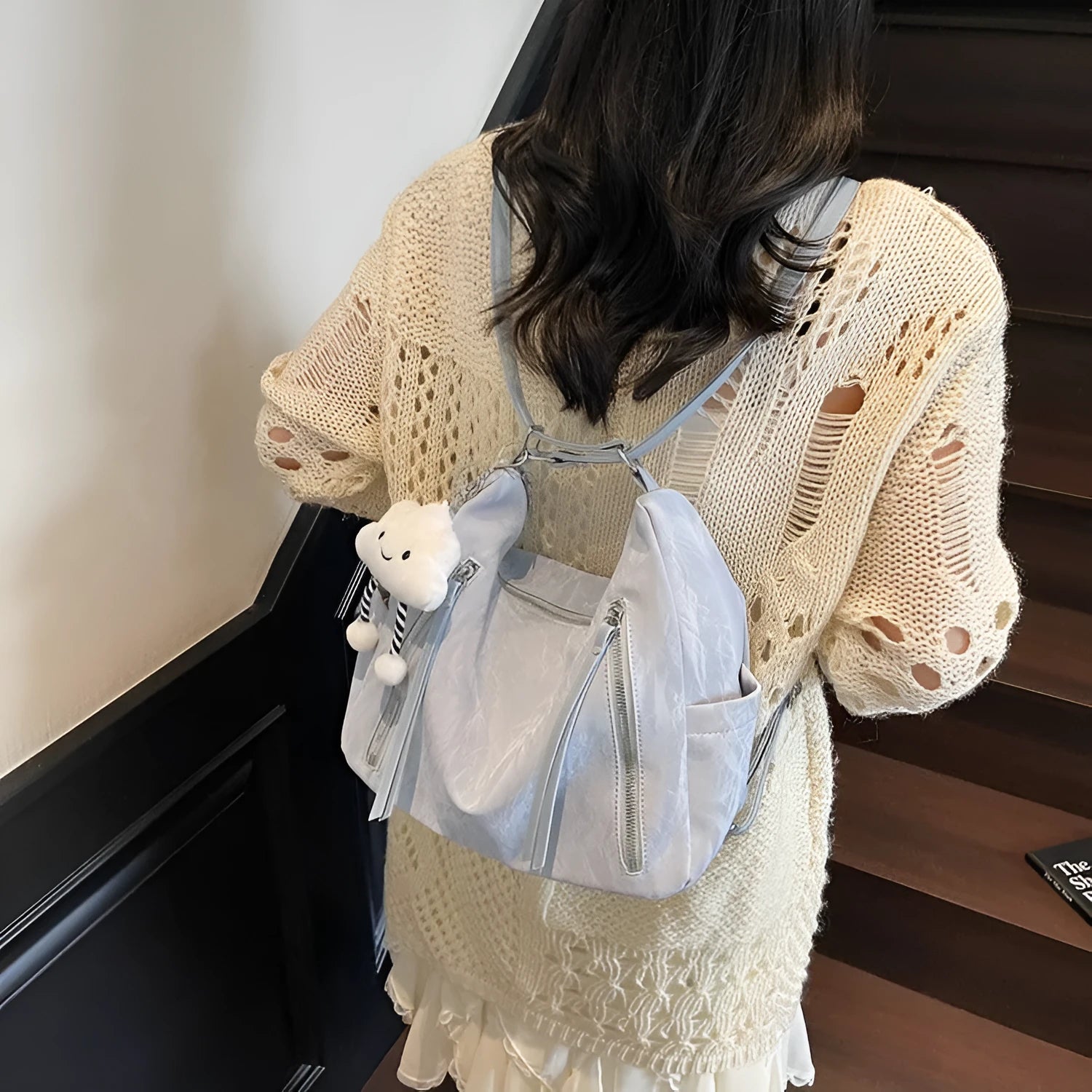 Women's soft PU fashion backpack in black, shown as a multi-functional shoulder bag with a pendant accessory.