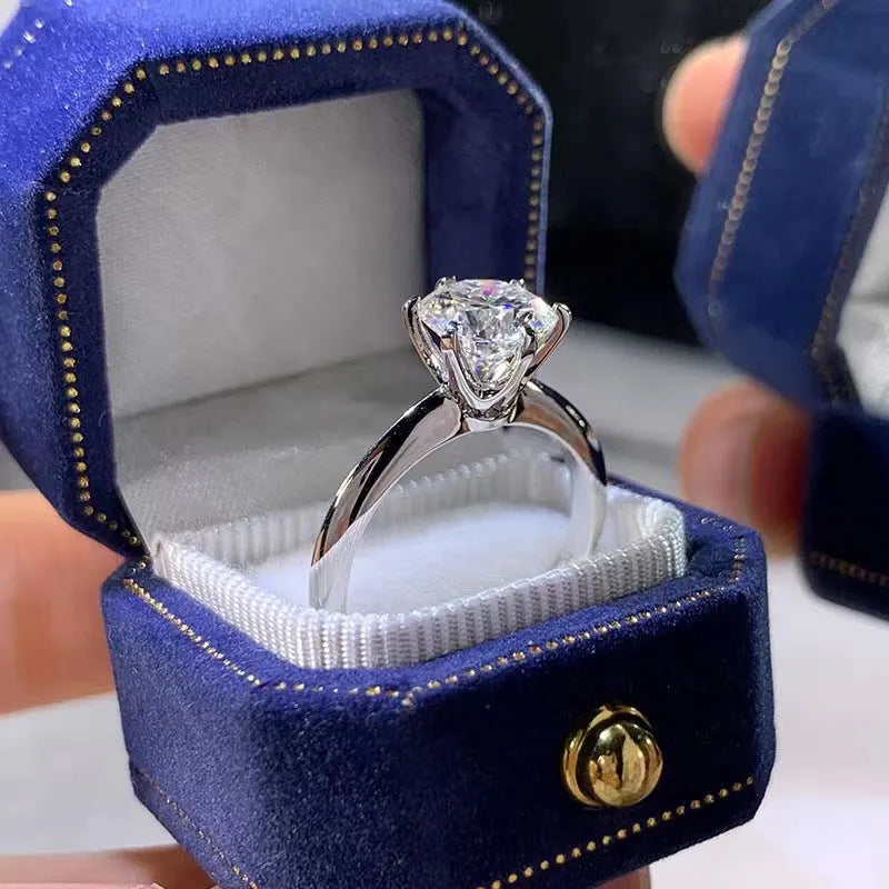 White gold plated geometric ring with a six-claw zircon setting on a hand.