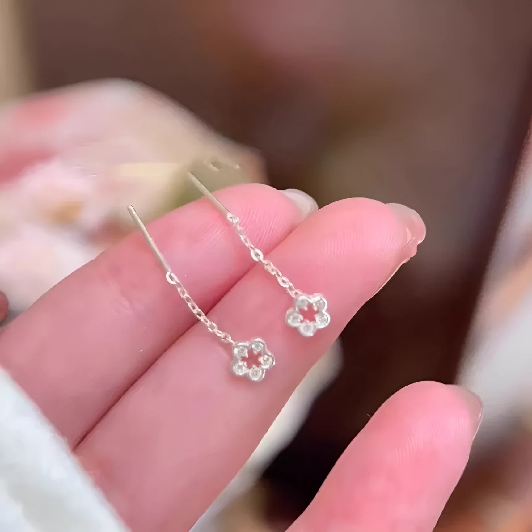 Silver hollow flower hanging earrings with petal design and alloy construction