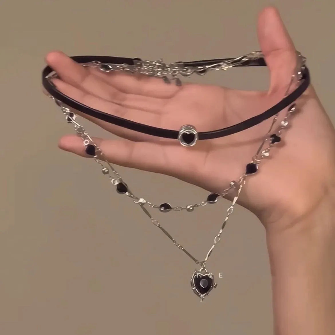 Women's twin necklace set with alloy heart pendants, artificial crystal details, and leather elements on clavicle chains