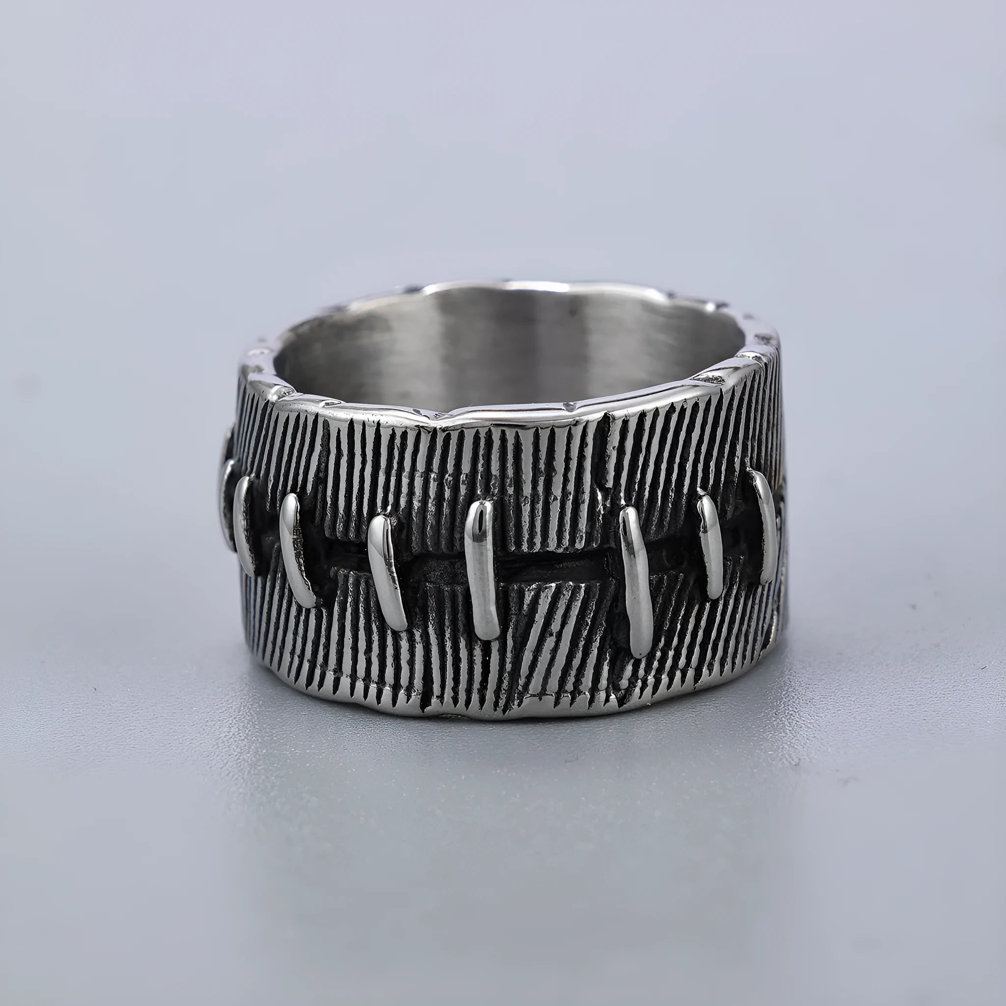 Geometric dark punk titanium steel double ring in retro colour on a black background.