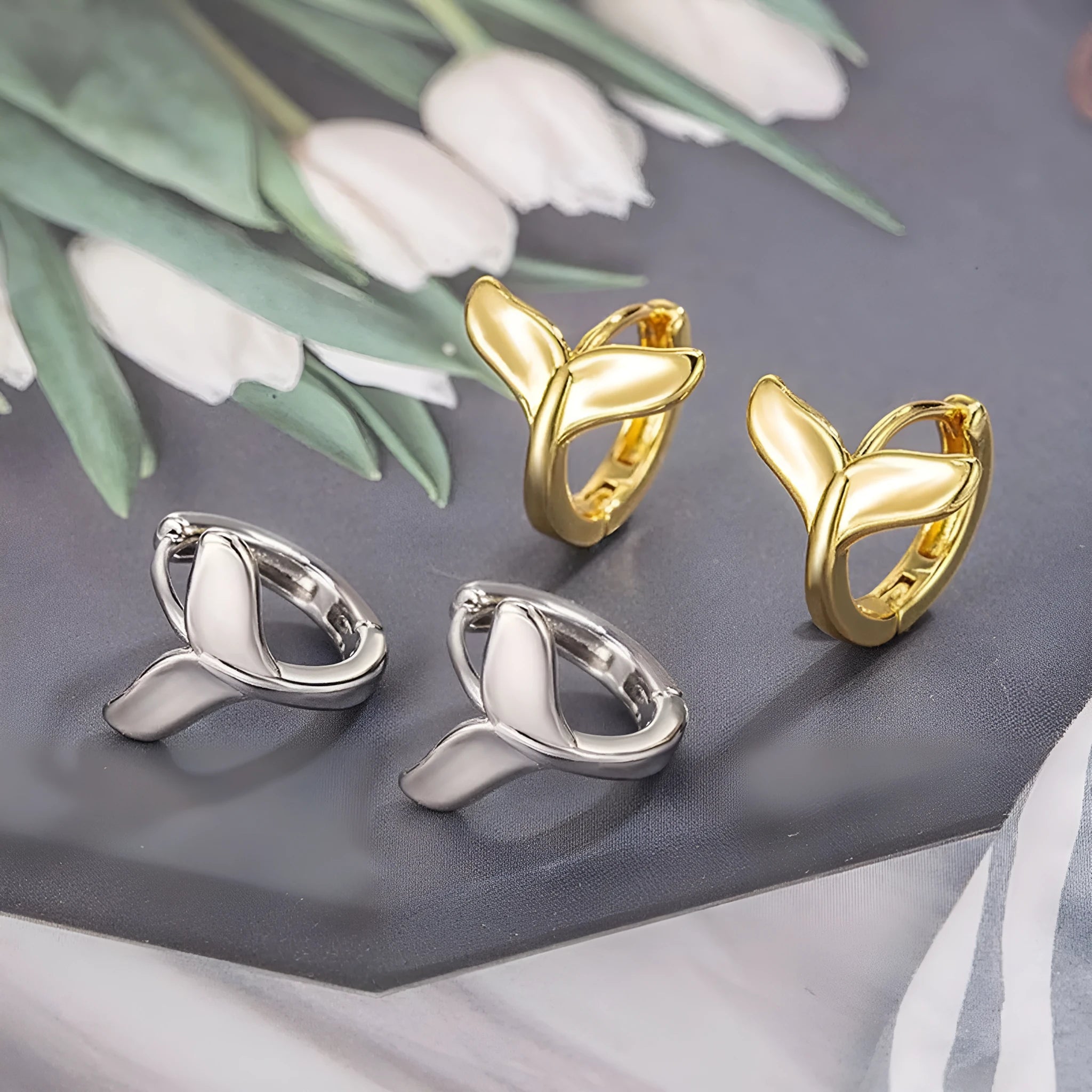 A pair of women's simple fishtail design earrings with an electroplated finish in white gold or yellow gold colour.