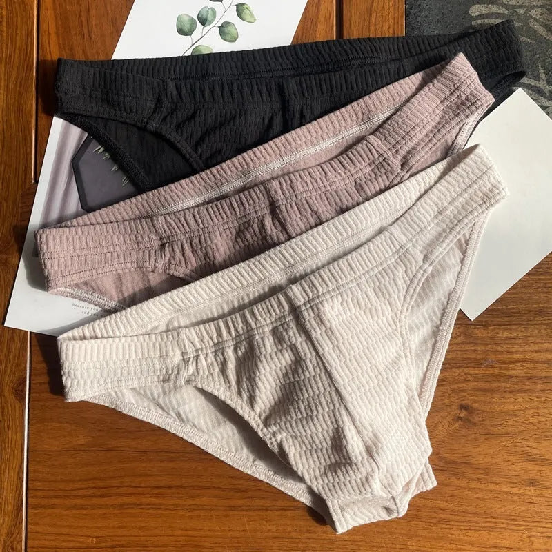 Men's solid colour cotton triangle briefs with a mid-waist waistband on a white background.