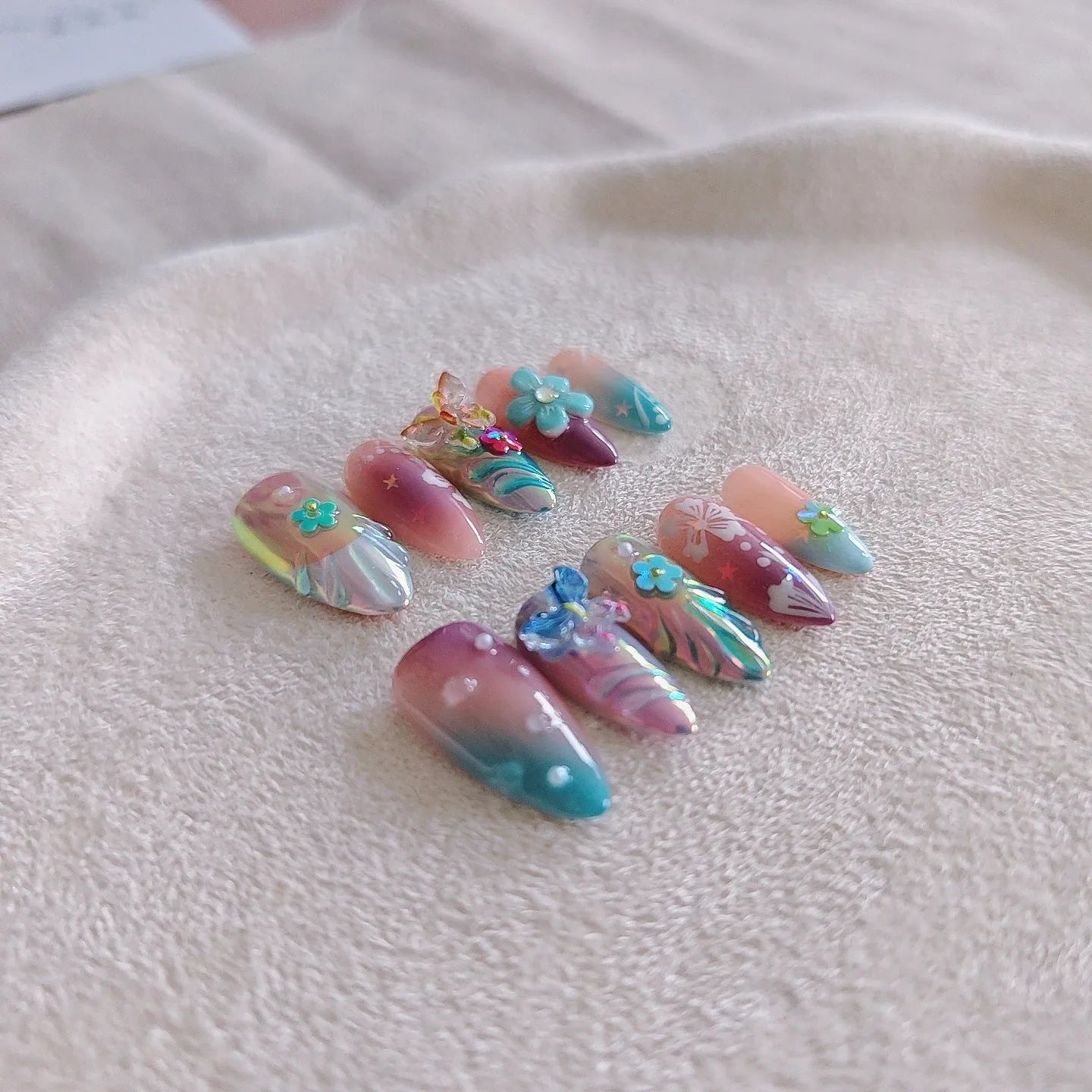 Handmade colourful manicure sculptures with floral butterfly designs for almond-shaped nails