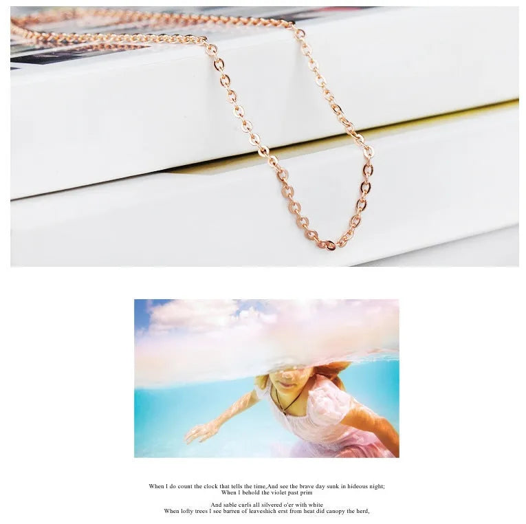 Rose gold cross chain necklace with a pink heart-shaped synthetic crystal pendant.