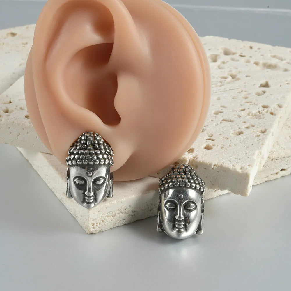 Stainless steel geometric earrings with hollow skull and Buddha head design in electroplated colour options.