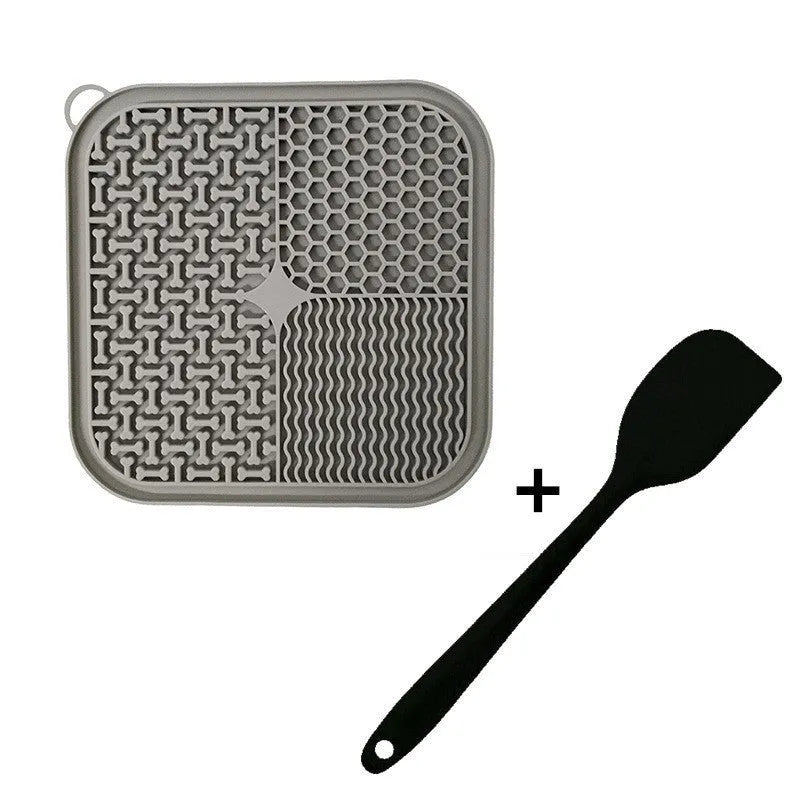 Blue silicone dog lick mat with textured surface and suction cups on back, shown on a tiled floor.