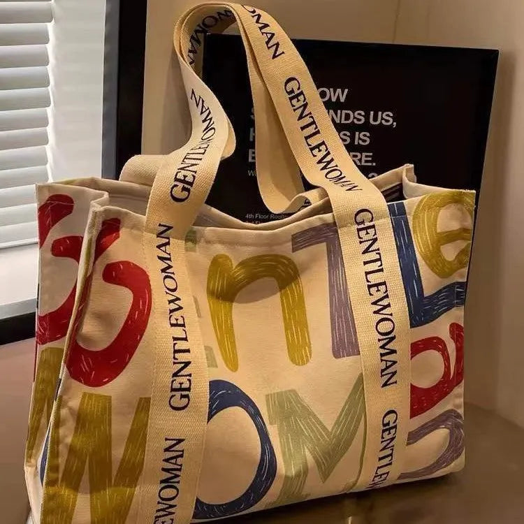 Large canvas women's travel tote bag with print design options including black letters and patterns.