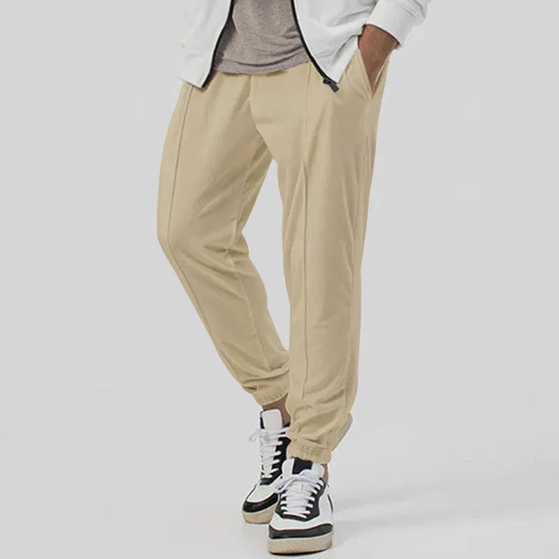 Men's grey casual track sweatpants with loose tapered cut and straight leg design, elastic waistband