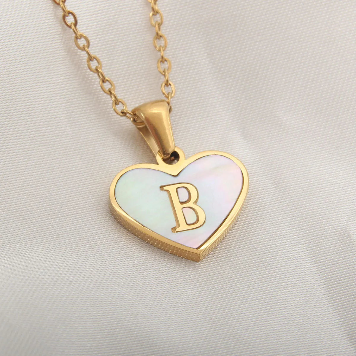 Gold plated heart-shaped personalised necklace with white shell charm on an adjustable chain.