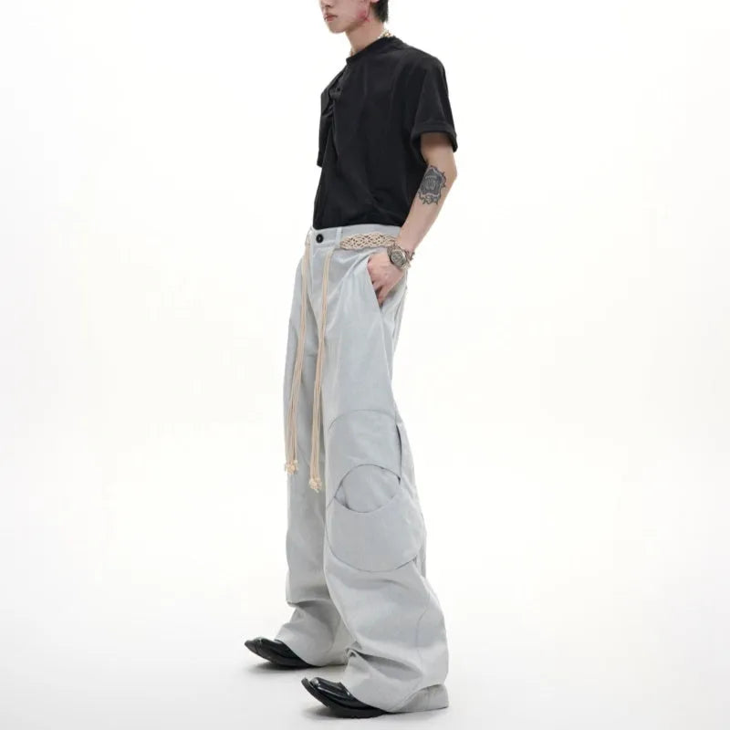 Man wearing dark blue straight-leg cotton jeans with heavy waistband stitching and decorative pocket details