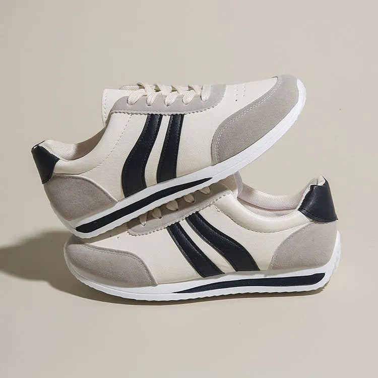 A pair of blue low-top lace-up running sneakers with a round toe and soft rubber sole on a white background.
