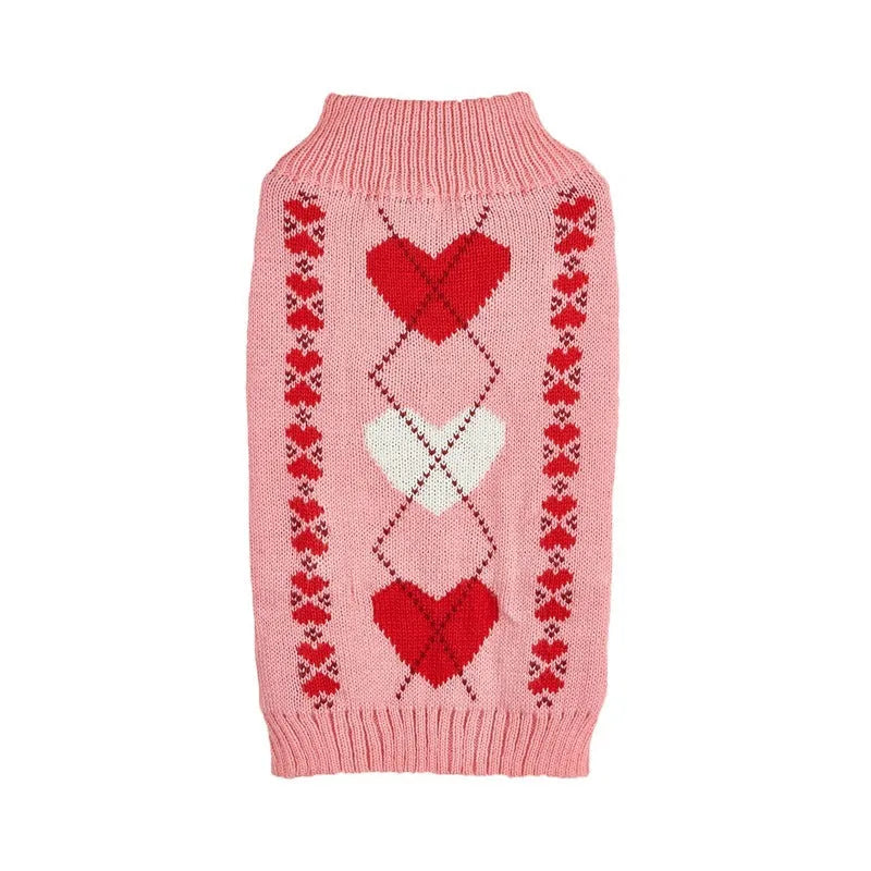 Dog wearing acrylic jumper with love heart and bow designs in red and pink colour patterns