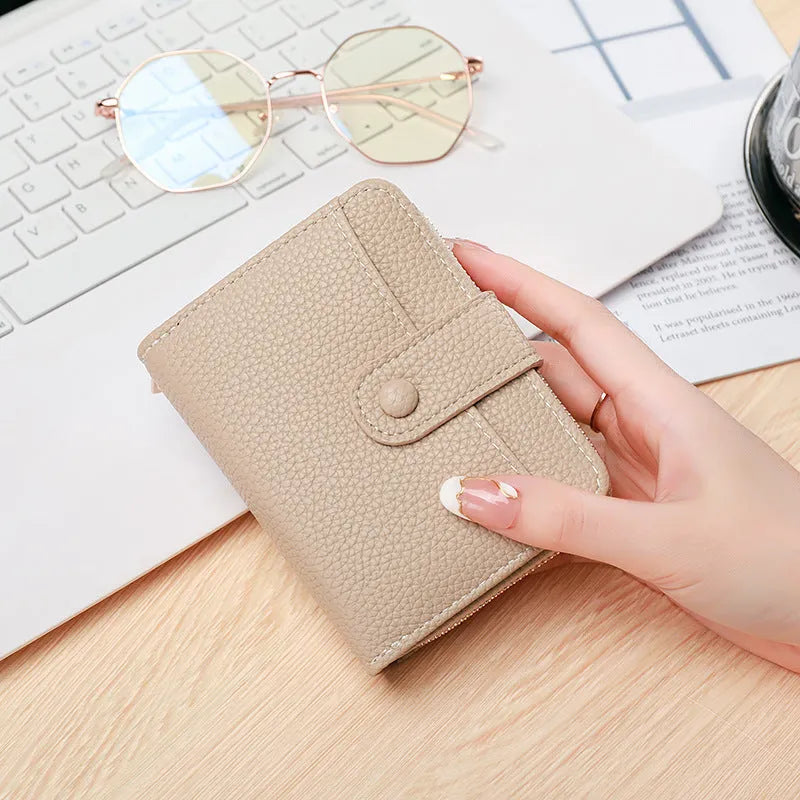 Ladies' short two-fold wallet in PU leather with a lychee pattern, shown in beige, pink, black, and red.