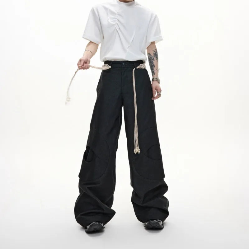 Man wearing dark blue straight-leg cotton jeans with heavy waistband stitching and decorative pocket details