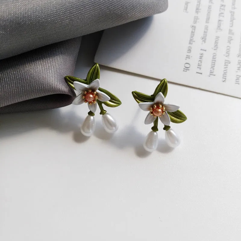 Alloy camellia flower earrings with sterling silver needle and contrasting colours including stud and clip options
