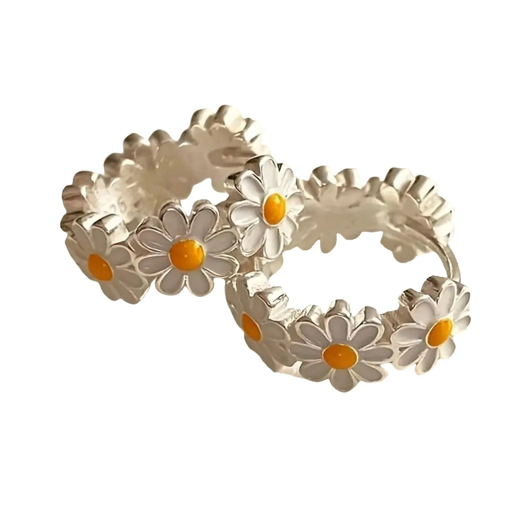White daisy flower ring style fashion earrings with inlaid gems on a model or plain background.
