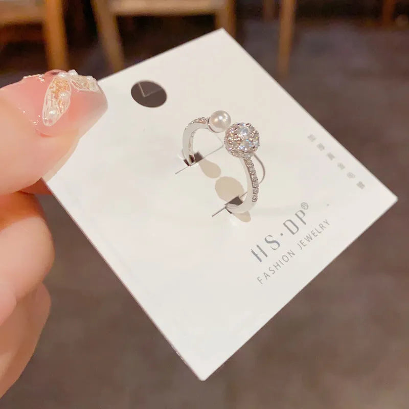 Open-end pearl ring with round zircon stone in gold or silver finish on geometric copper band