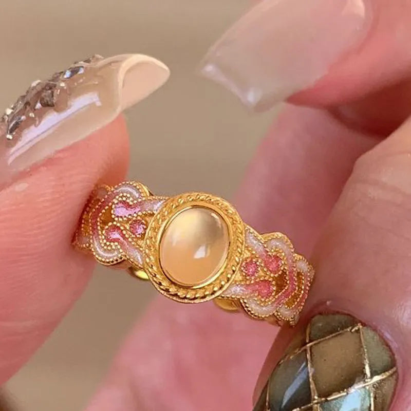 Women's geometric open ring with pink crystal enamel detail on gold-plated copper.