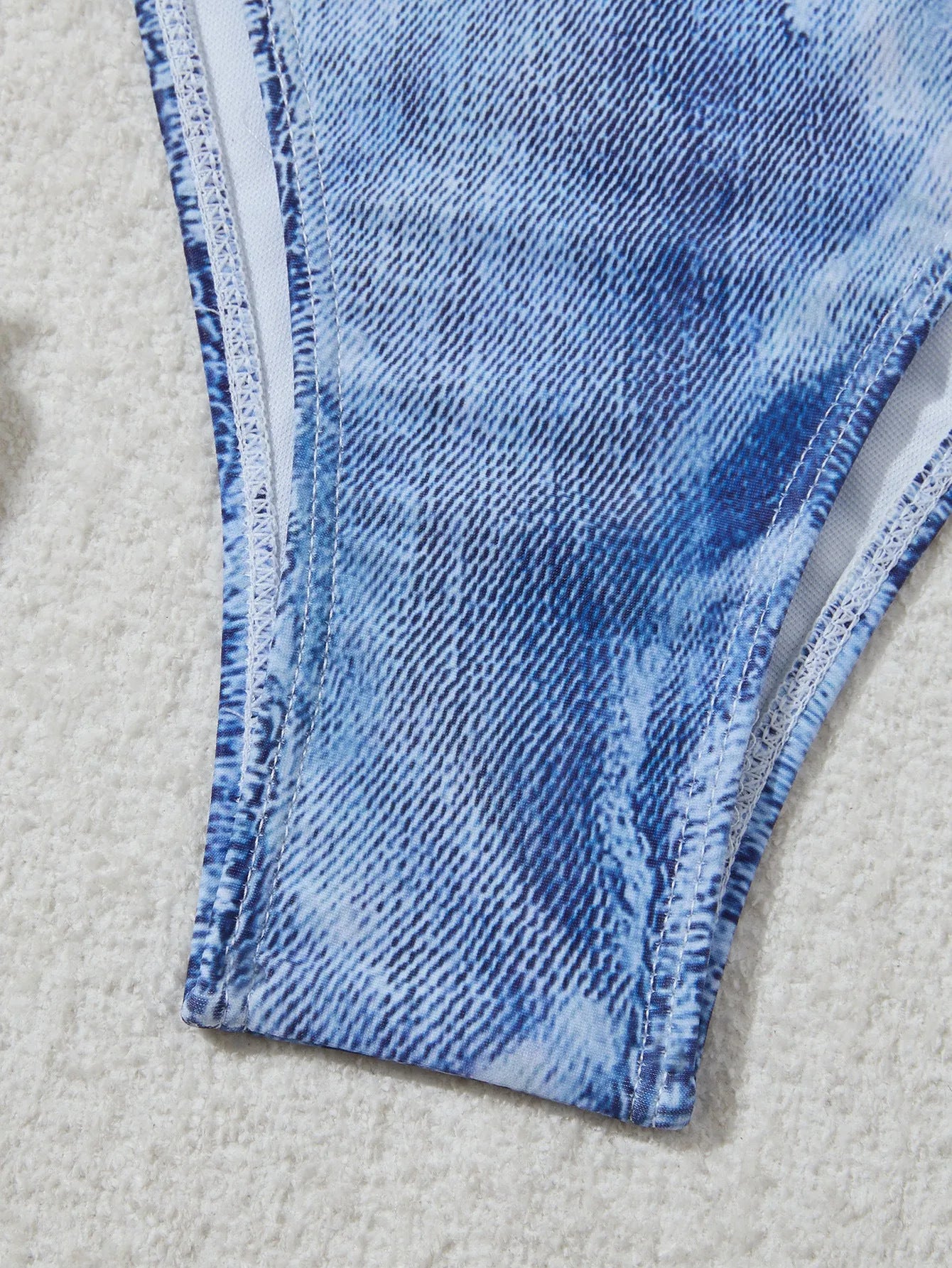 Women's denim blue printed bikini swimsuit with strap design on a hanger
