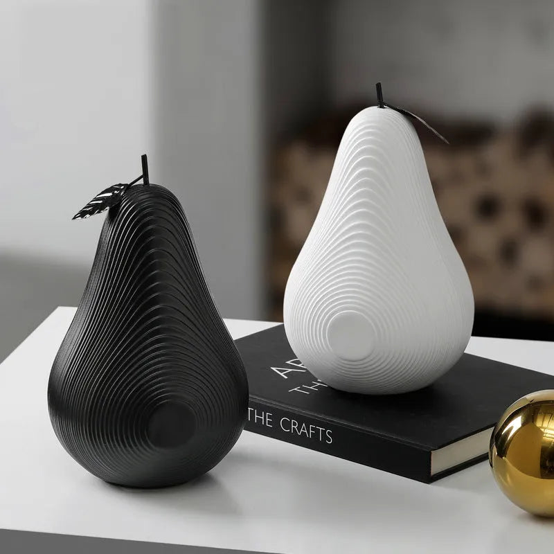 Resin decorative sculptures of apples and pears in black, white, orange and blue colours.