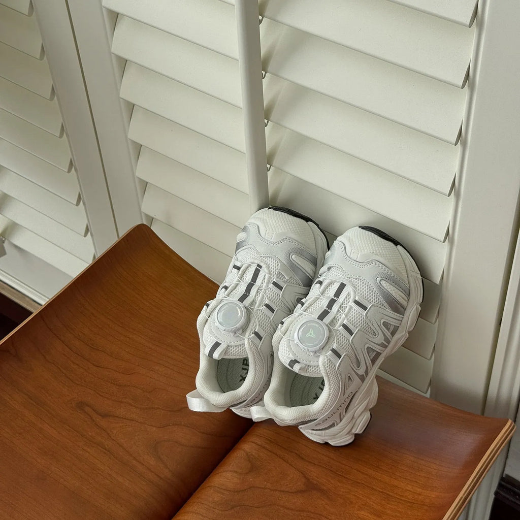 Pair of beige unisex casual shoes with PU leather mesh uppers on a plain background.