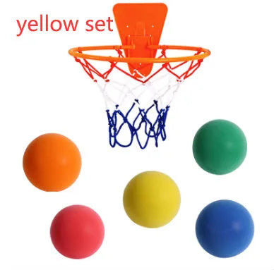 Silent high density foam sports ball in assorted bright colours next to a basketball frame.