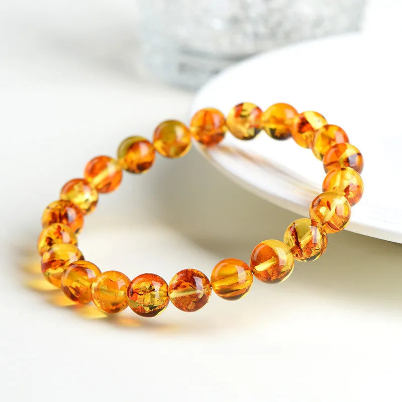 Natural yellow piebald amber bracelet with geometric design and polished Baltic amber beads
