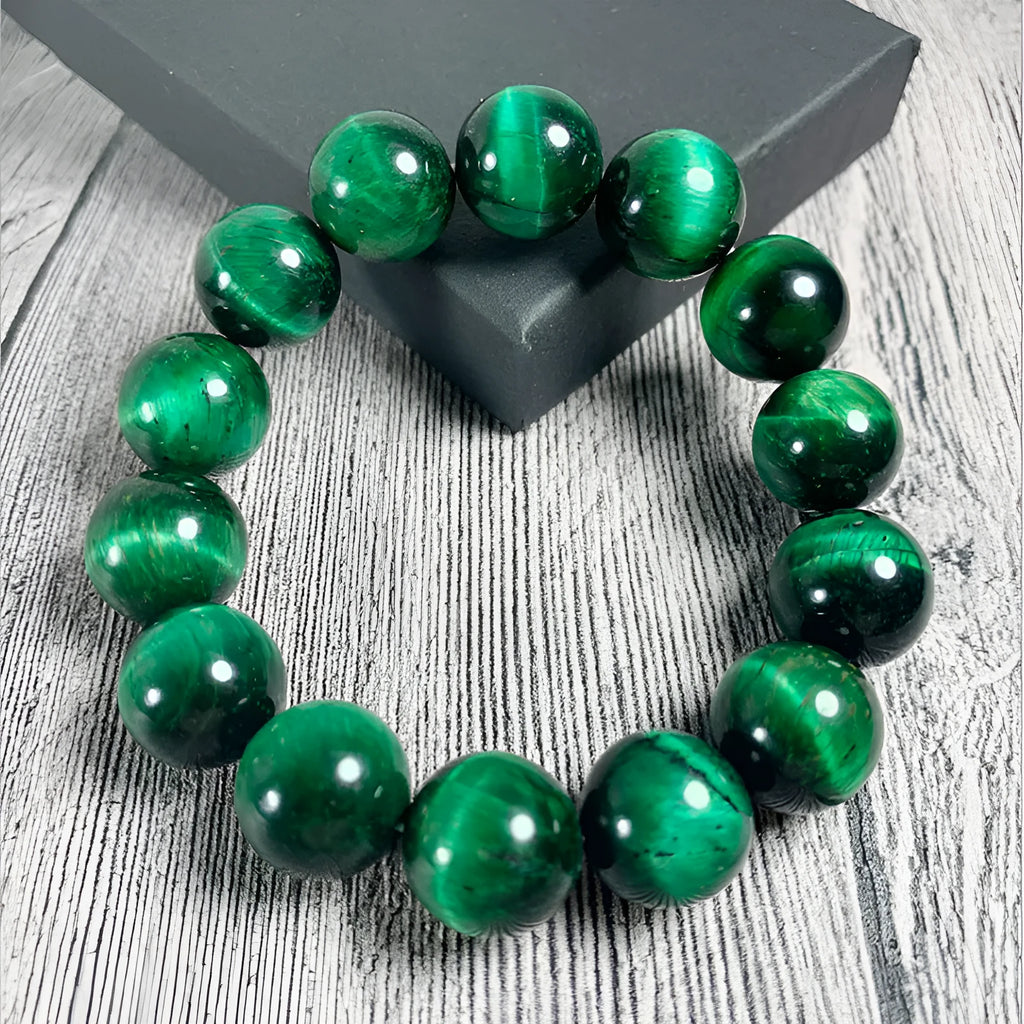 Polished green tiger eye stone bead bracelet with geometric beads on a wrist.