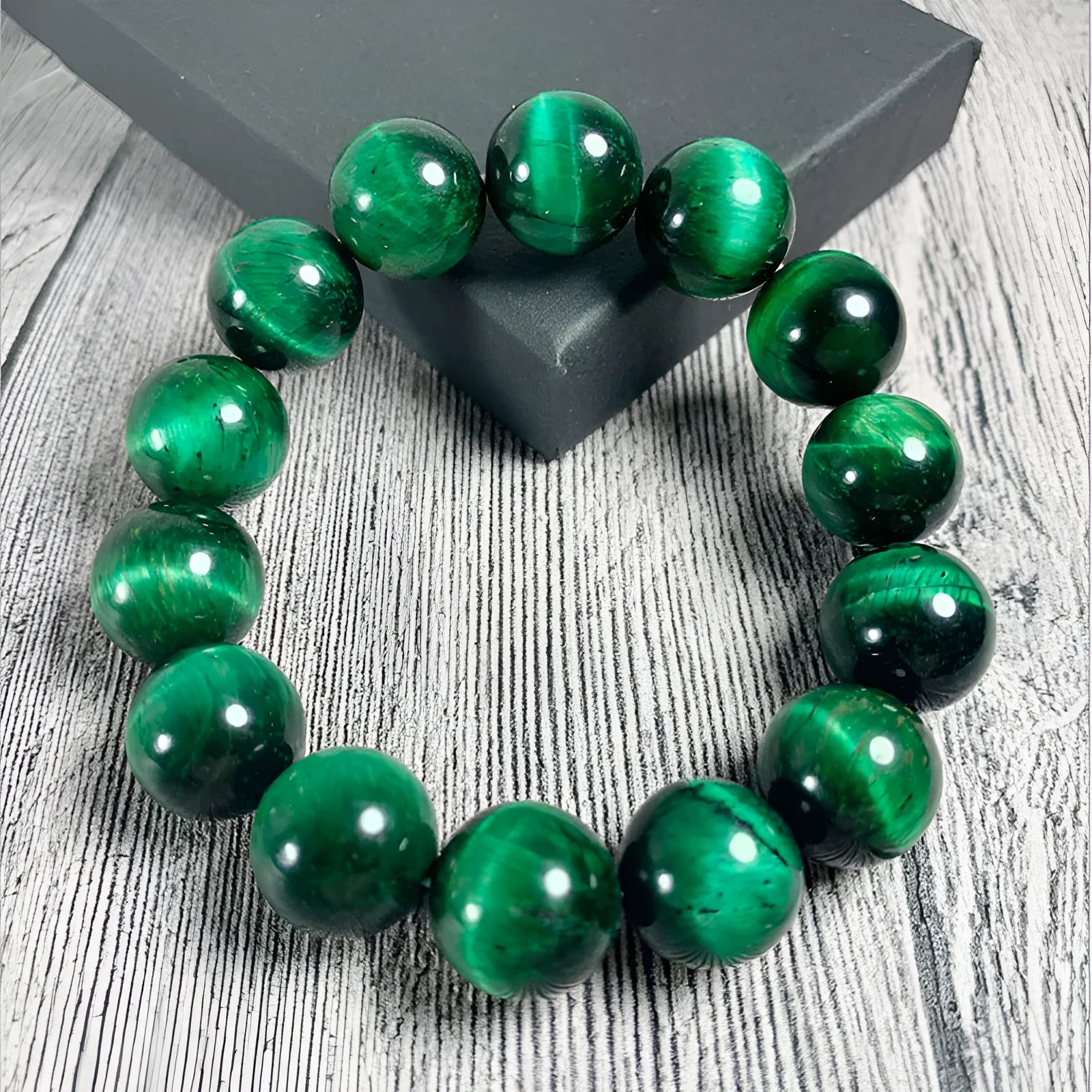 Polished green tiger eye stone bead bracelet with geometric beads on a wrist.