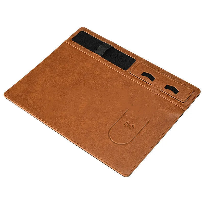 Pink PU leather wireless charging mouse pad with integrated phone holder on a desk.