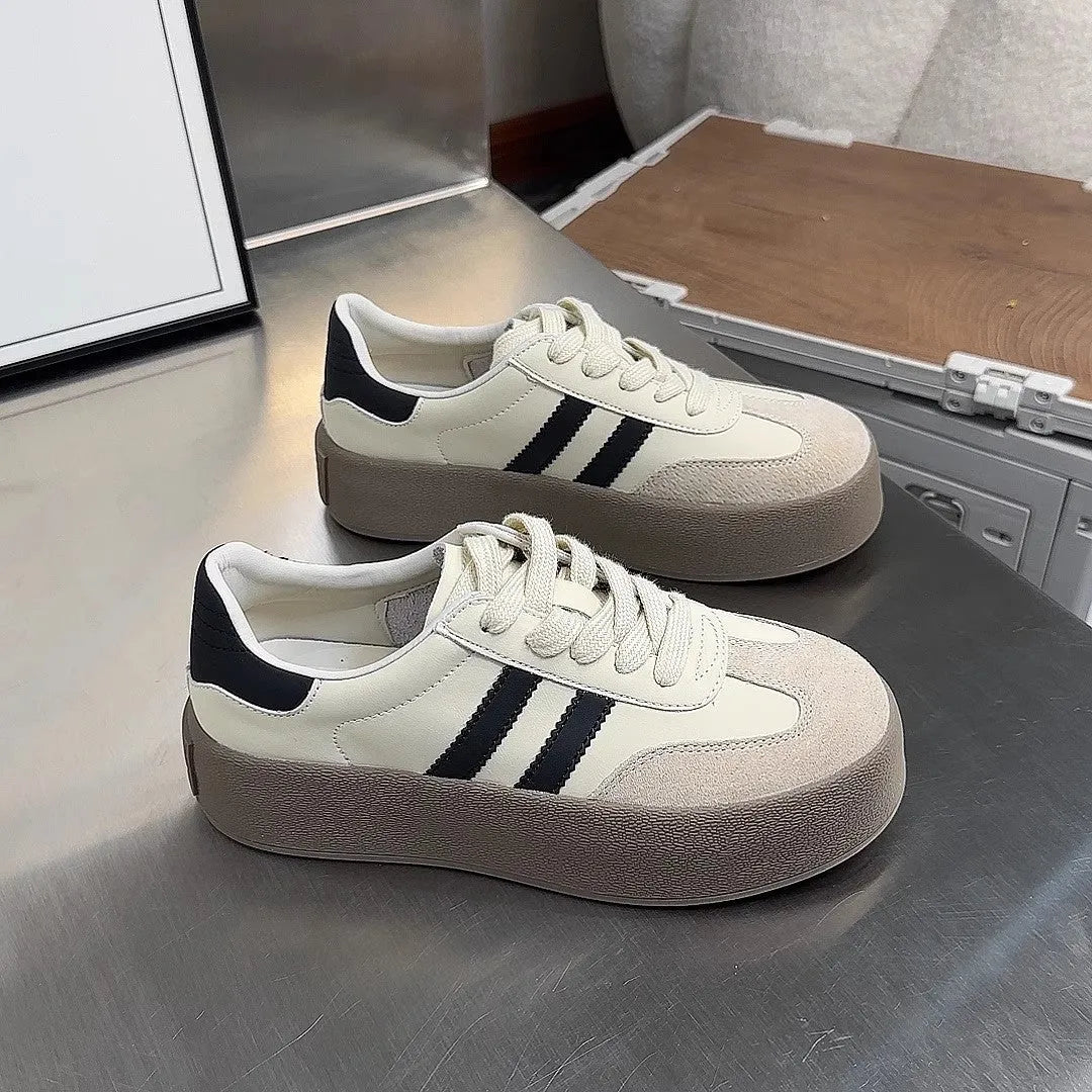 Women's beige distressed leather lace-up sneakers with round toe and rubber sole on a neutral background.