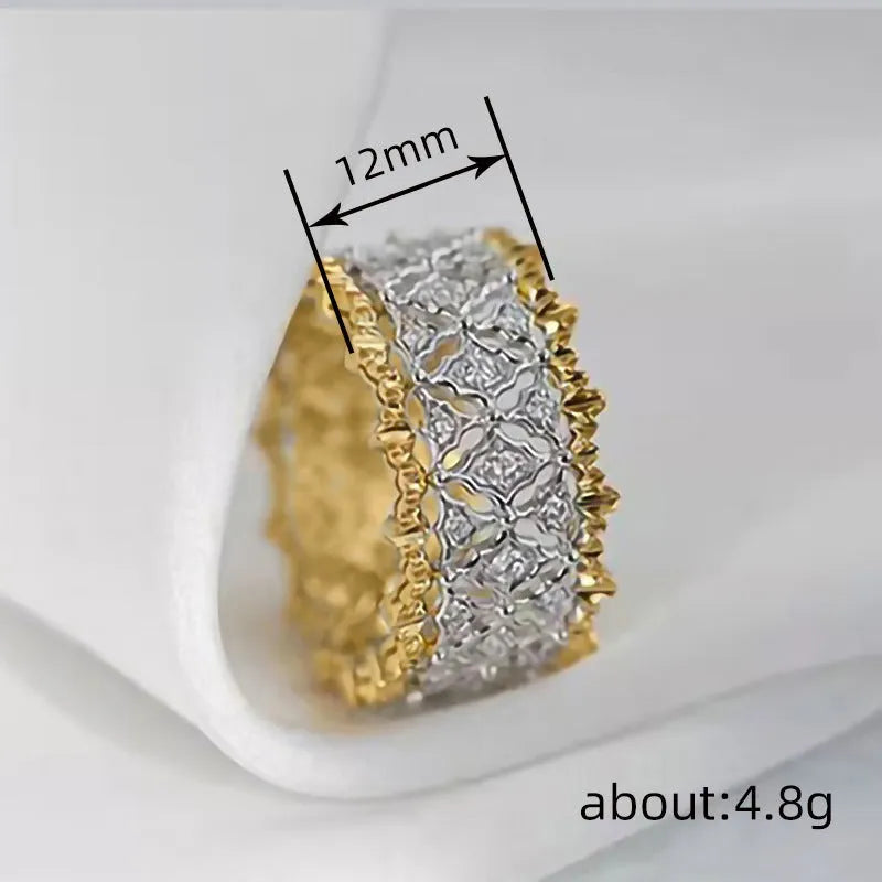 Gold two-tone copper ring with round geometric zircon centrepiece on a plain background.