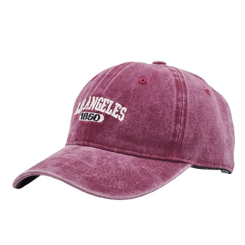 Retro peaked cap with distressed letter embroidery and adjustable sizing in conical crown design