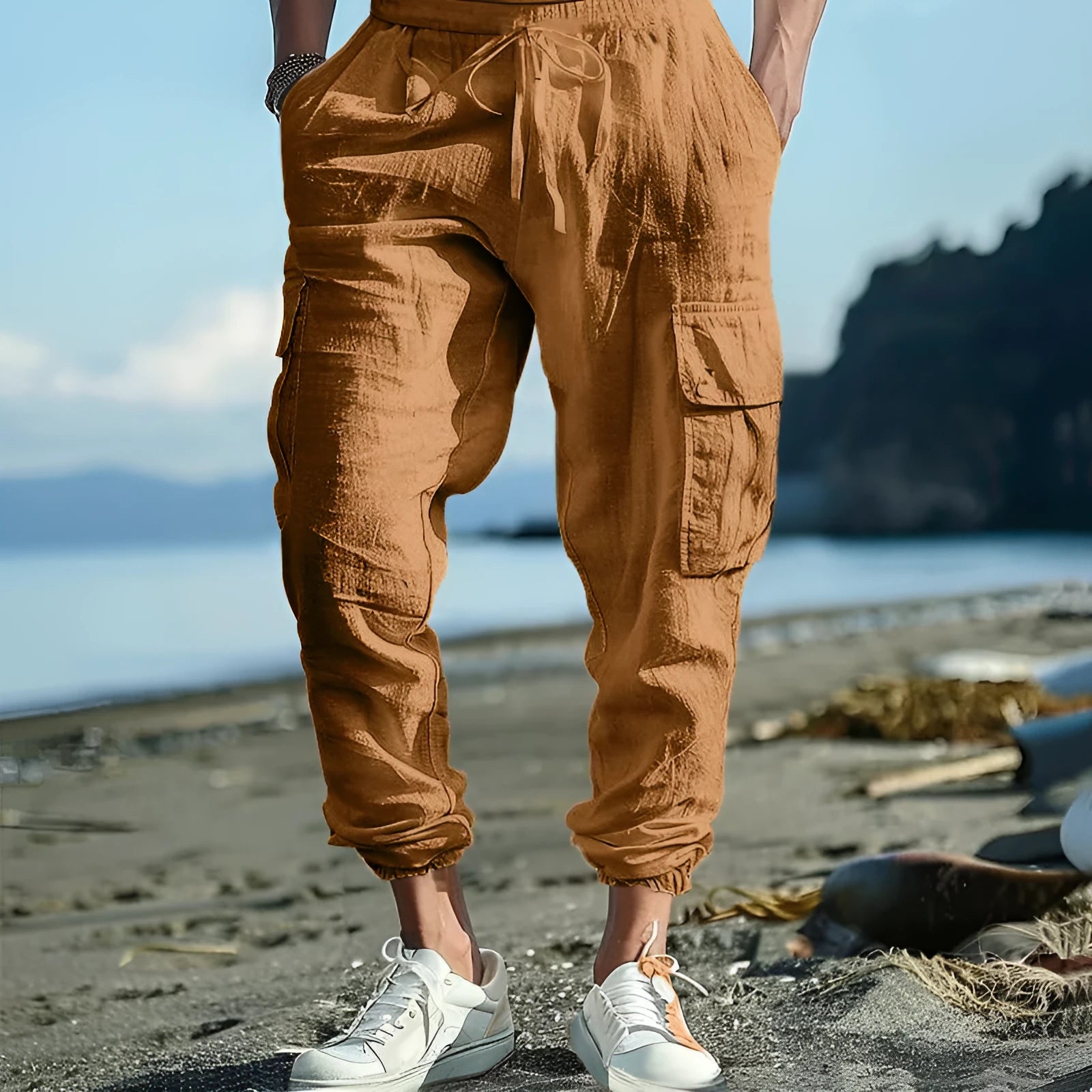 Man wearing loose, ankle-tied linen trousers in a solid colour with visible pockets.